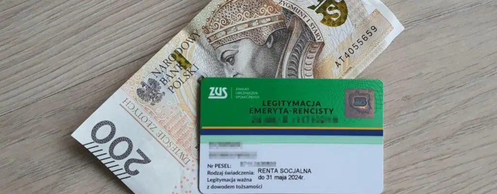 Zdjęcie w artykule - renta socjalna. Widoczna legitymacja rencisty socjalnego ZUS leżąca na banknocie 200-złotowym.